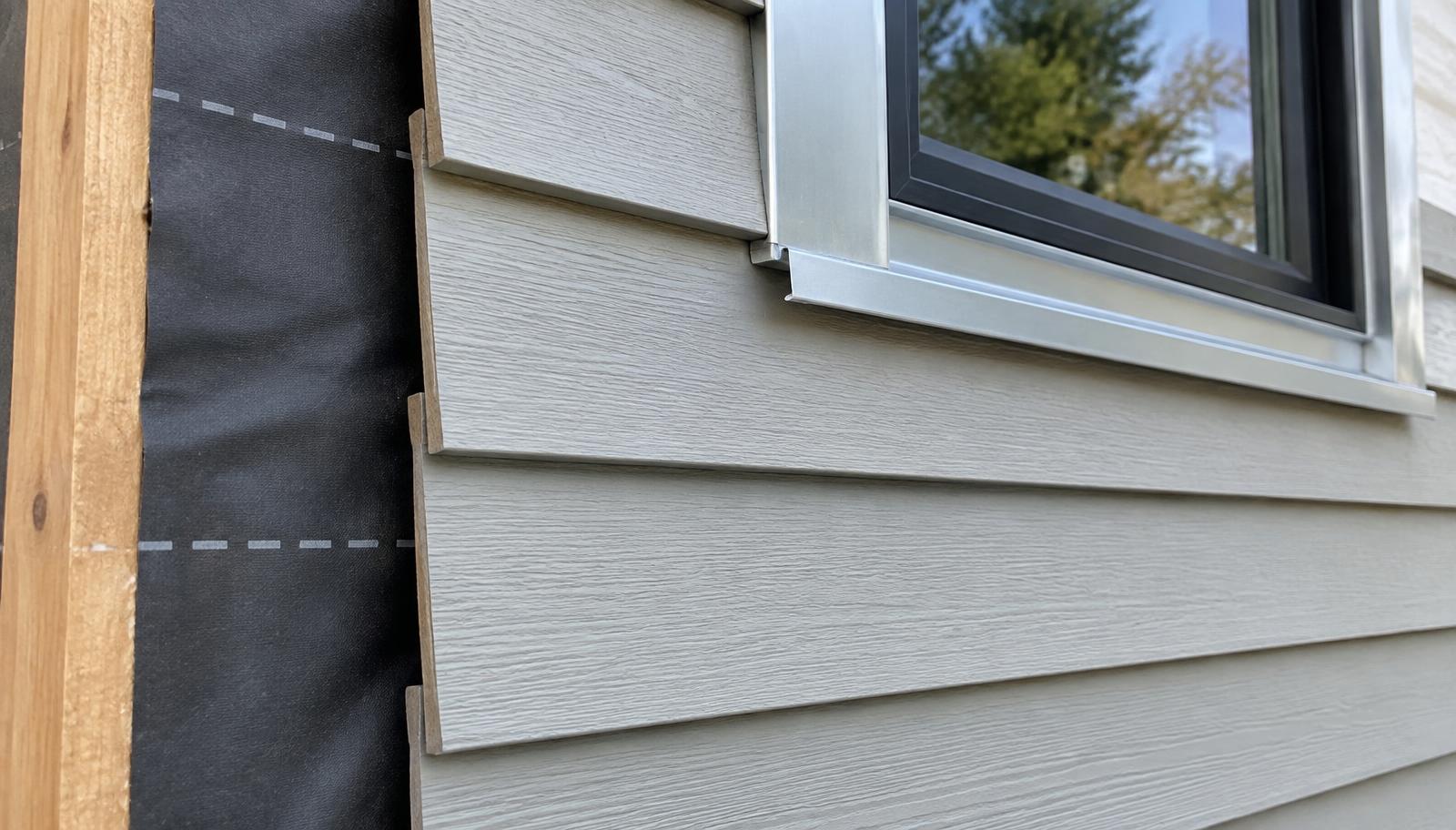 Lap siding installation detail with weather-resistive barrier and metal flashing at a window opening